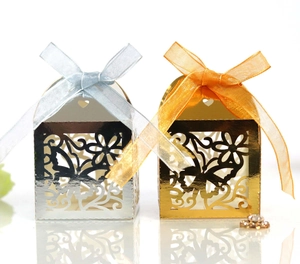 Detail of laser-cut butterfly gift boxes in gold and silver with matching satin ribbons