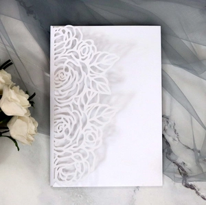 Detailed laser cut white rose flower patterns on an elegant wedding invitation card