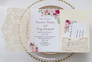 Detailed laser-cut ivory wedding invitation with elegant floral watercolor card insert
