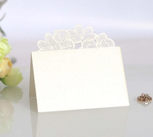 Detail of laser-cut rose floral wedding place card with pearlescent finish and blank space