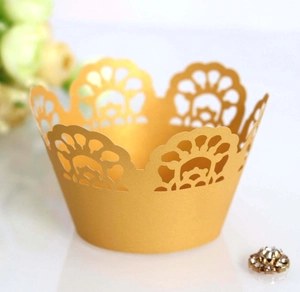 Close-up of golden laser-cut lace cupcake wrappers with elegant crown pattern