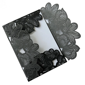 Detailed laser-cut floral pattern on navy blue wedding invitation card with paper texture