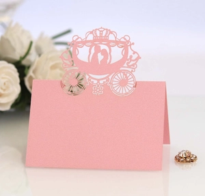 Pink laser cut wedding escort card with pumpkin carriage design and crown detail