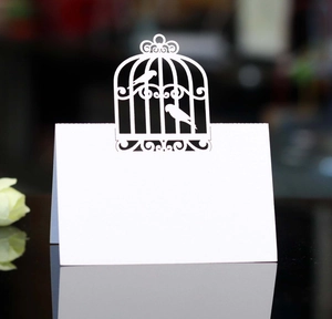 Détail du design de cage d'oiseaux découpé au laser sur marque-place blanc de mariage