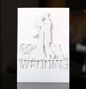 Detail of laser-cut white wedding invitation with silhouettes and Mr & Mrs text