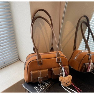 Détail d'un sac à bandoulière en daim avec boucles vintage et charmant ours en peluche