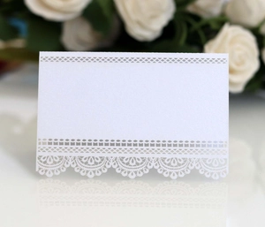 Detailed macro of white laser-cut lace place card with pearlescent finish for weddings