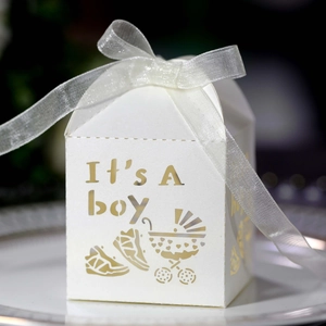 Macro detail of white laser-cut 'It's A boy' gift box with delicate organza ribbon bow