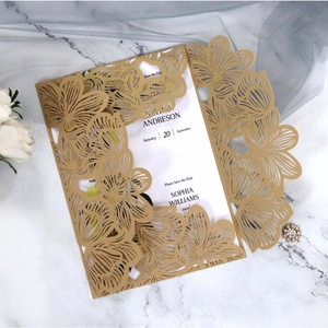 Elegant laser-cut floral wedding invitation with gold pearl shell on marble background
