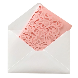 Close-up of laser-cut pink wedding invitation with floral patterns and a white envelope