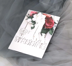 Detail of laser-cut wedding invitation featuring Mr & Mrs silhouette and floral inner page