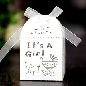 Detail of white laser-cut 'It's A Girl' baby shower favor box with organza ribbon bow