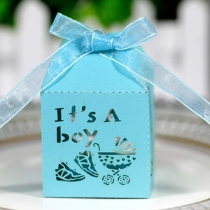 Close-up of blue laser-cut baby shower candy box with It's A Boy text and ribbon bow
