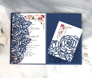 Macro view of laser-cut navy blue rose pattern on an elegant wedding invitation