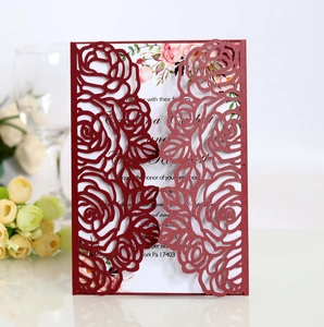 Macro view of laser-cut burgundy rose patterns on a business wedding invitation card