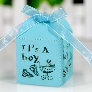 Macro shot of light blue laser-cut candy box featuring It's A boy text and baby stroller