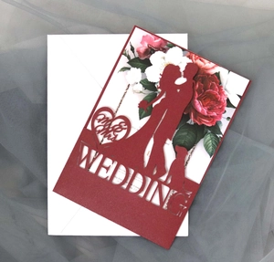 Macro detail of laser cut wedding invitation with red hollow heart and Mr & Mrs design