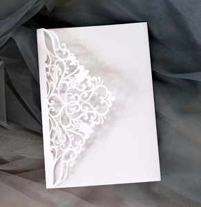 Détail de la carte d'invitation blanche découpée au laser avec motif floral élégant