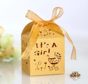 Détail boîte à bonbons dorée découpée au laser avec texte It's A Girl et ruban chic