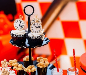 Detail of black laser-cut lace cupcake wrappers and clock toppers for party decor