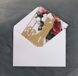 Detail of laser-cut wedding invitation featuring a romantic silhouette and floral liner