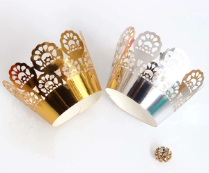 Macro detail of laser-cut crown cake wrappers in gold and silver with rhinestone accents