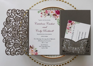 Macro detail of laser-cut vine pattern on deep gray cardstock wedding invitation