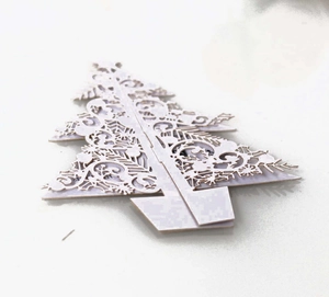 Intricate white laser-cut 3D Christmas tree ornament with elegant paper scrollwork