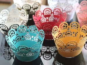 Detailed laser-cut lace cupcake wrappers in multiple vibrant colors for party decorations