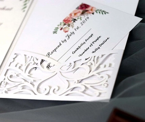 Détail macro de l'invitation de mariage découpée au laser avec motifs floraux élégants