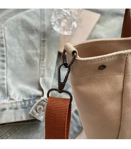 Detailed macro view of high-quality metal hardware and canvas strap stitching