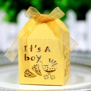 Macro shot of laser-cut 'It's A Boy' yellow candy box with baby stroller patterns