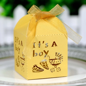 Macro detail of laser-cut It's A Boy paper gift box with baby stroller and gold ribbon