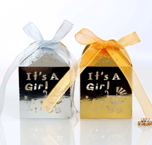 Détail de boîtes à cadeaux It's A Girl ajourées en miroir doré et argenté avec rubans