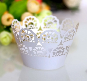 Intricate laser-cut white lace cupcake wrapper with floral patterns for wedding decoration