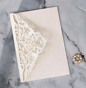 Détails de la découpe laser florale sur une élégante carte d'invitation crème nacrée