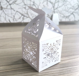 Detailaufnahme der weiß gelaserten Gastgeschenkbox mit Kreuzmuster und Schmetterling