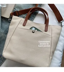Canvas tote bag detail showing back pocket for phone storage and brown leather strap