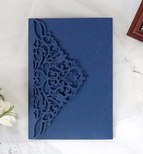Détail d'une pochette d'invitation bleu marine découpée au laser avec motifs