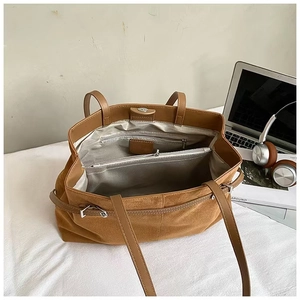 Vue intérieure du sac cabas marron avec compartiments zippés et espace laptop