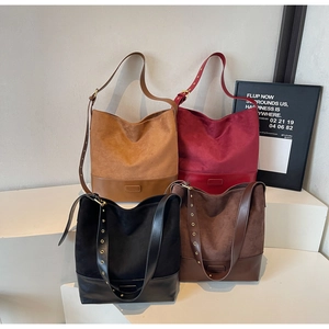 Detail of four suede and leather bucket bags in camel, burgundy, black, and dark brown
