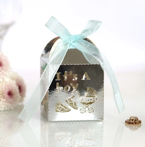 Detail of silver laser-cut favor box with 'It's A Boy' text and blue silk ribbon
