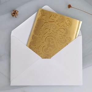 Laser-cut gold hollow wedding invitation card with elegant floral patterns and white envelope