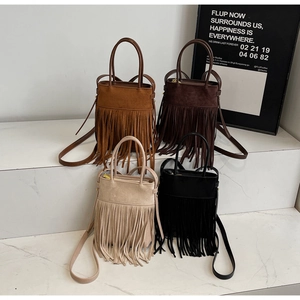 Vue détaillée de sacs seaux bohèmes en daim avec de longues franges en quatre couleurs