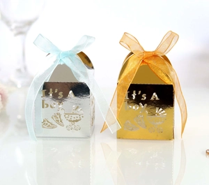 Detail of laser-cut It's A Boy baby shower candy boxes with strollers and silk ribbons