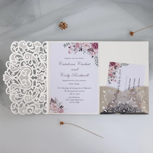 Detailed view of laser-cut floral wedding invitation with cream cover and floral inner cards