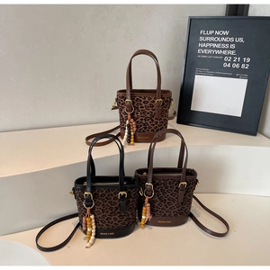 Detailed view of leopard print bucket bags in three colors with beaded tassel charms
