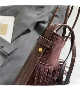 Détail du sac seau marron vintage montrant les franges et la texture du cuir suédé