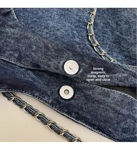 Close-up of washed denim tote with strong magnetic buckle and metal chain strap