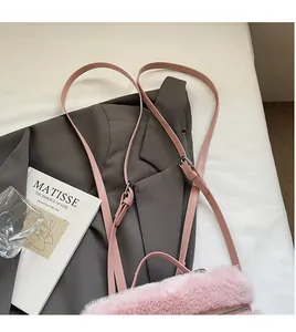 Detail of plush pink crossbody bag featuring adjustable leather strap and metal zipper